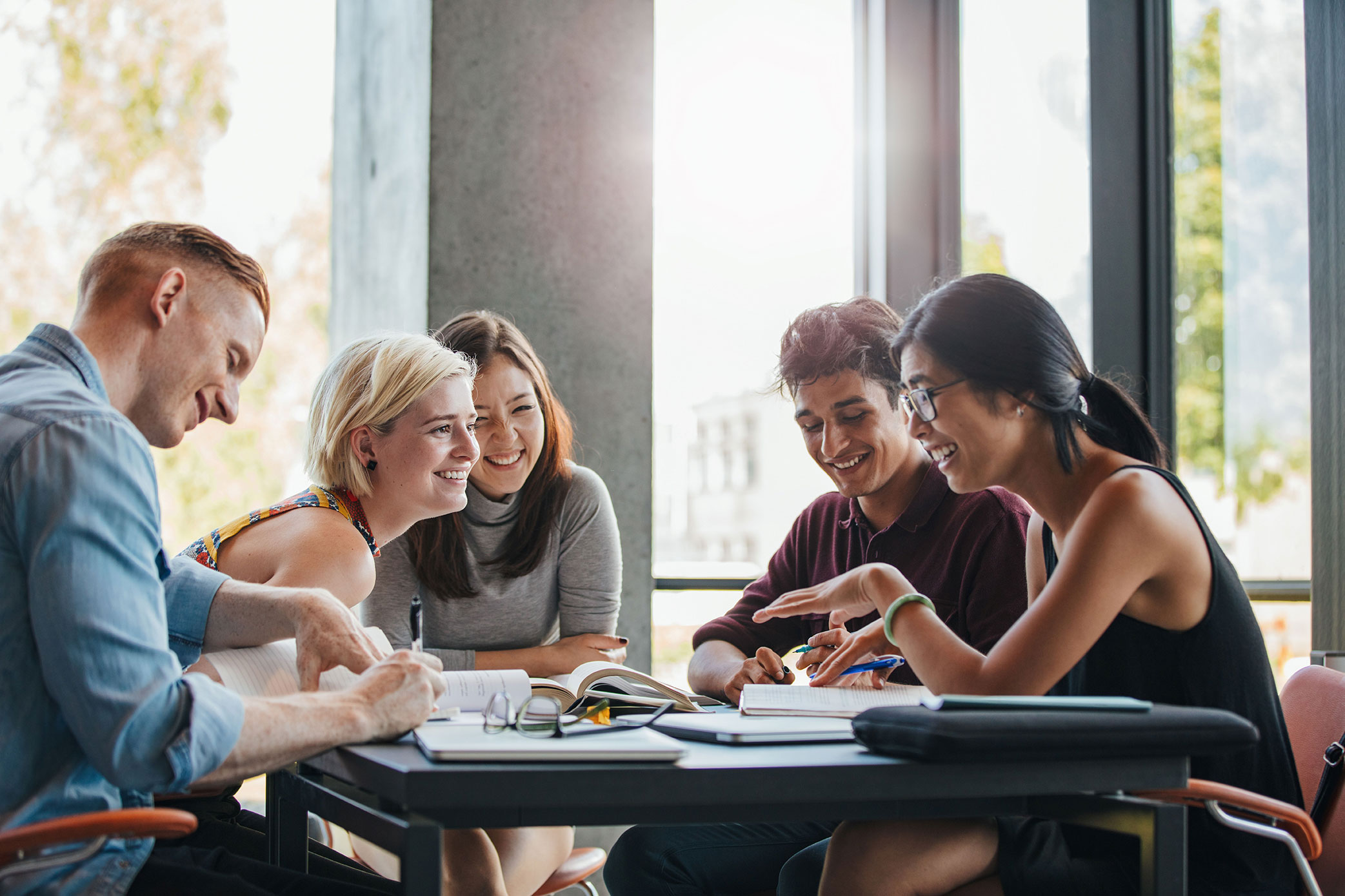 A group of young people work together at a table.